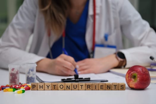 A dedicated healthcare professional is studying the beneficial phytonutrients found in an apple and various vitamins