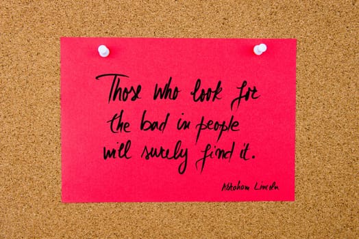 Quote Those who look for the bad in people will surely find it by Abraham Lincoln, written on red paper note pinned on cork board with white thumbtacks, copy space available