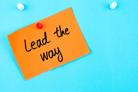 Lead The Way written on orange paper note pinned on cork board with white thumbtack, copy space available