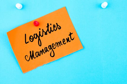 Logistics Management written on orange paper note pinned on cork board with white thumbtack, copy space available