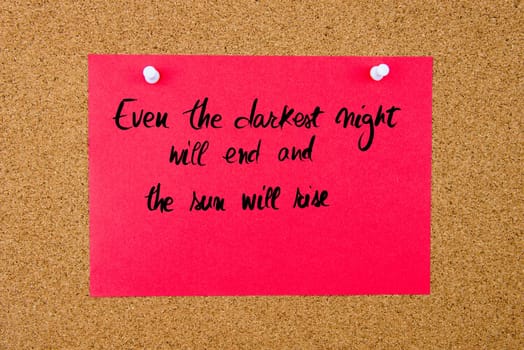 Red paper note with handwritten text Even The Darkest Night Will End and The Sun Will Rise pinned on cork board with white thumbtacks