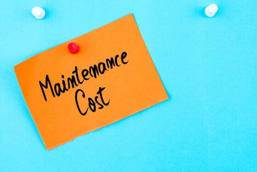 Maintenance Cost written on orange paper note pinned on cork board with white thumbtack, copy space available