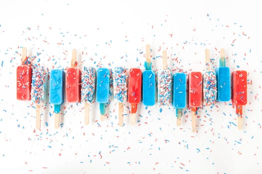 Colorful popsicles with sugar sprinkles on white