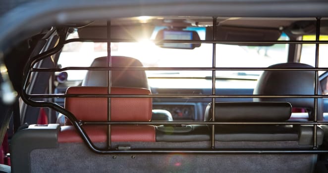 The car's interior in the sun. Back view. The dashboard is blurred.