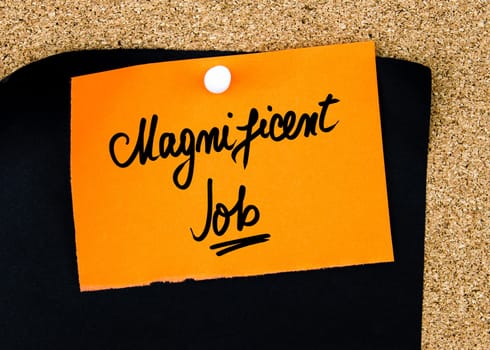 Magnificent Job written on orange paper note pinned on cork board with white thumbtacks, copy space available