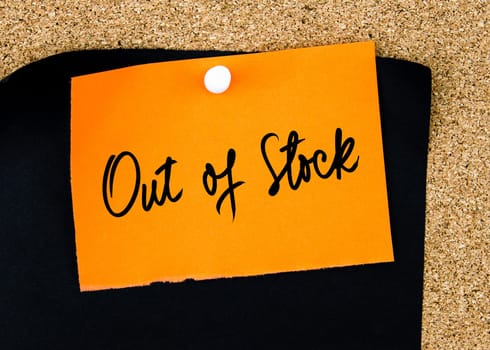 Out Of Stock written on orange paper note pinned on cork board with white thumbtacks, copy space available