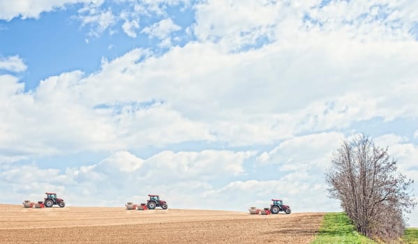 Farm work. Tractor compresses the soil after planting with rollers.