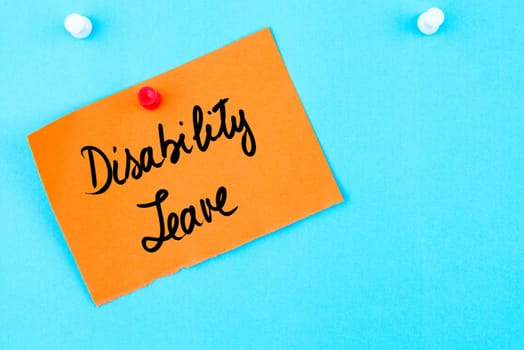 Disability Leave written on orange paper note pinned on cork board with white thumbtack, copy space available
