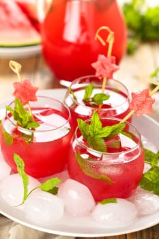 Watermelon juice with mint and ice on wooden rustic table.