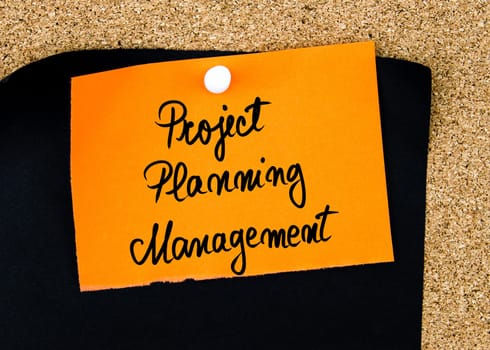 Project Planning Management written on orange paper note pinned on cork board with white thumbtacks, copy space available