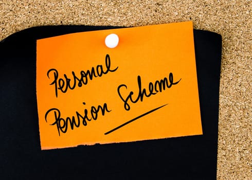 Personal Pension Scheme written on orange paper note pinned on cork board with white thumbtacks, copy space available