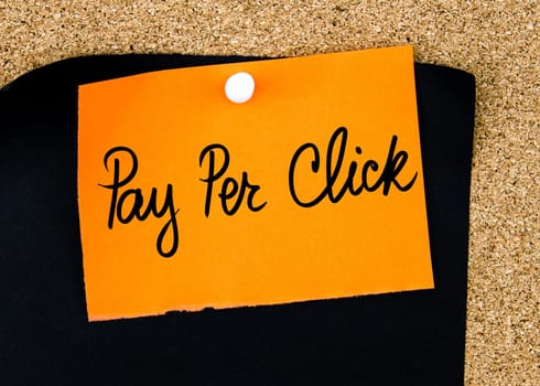 Pay Per Click written on orange paper note pinned on cork board with white thumbtacks, copy space available