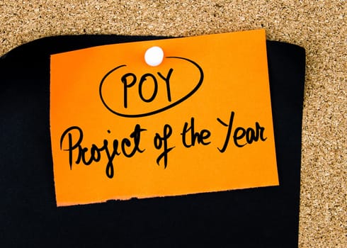 Business Acronym POY as Project Of The Year written on orange paper note pinned on cork board with white thumbtacks, copy space available
