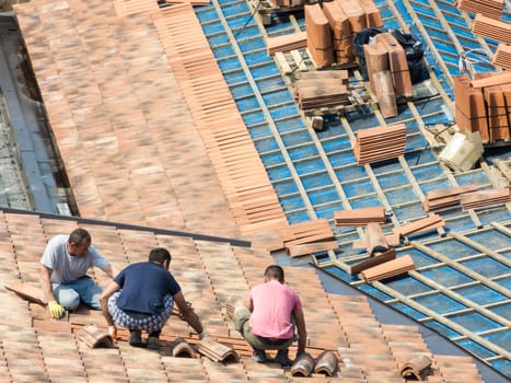 Construction site. Masons to work on the roof for laying tiles
