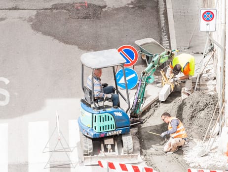 Sidewalk under construction, curb and gutter installation in progress  Construction workers.
