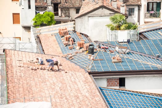 Construction site. Masons to work on the roof for laying tiles