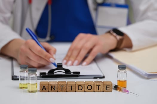 A knowledgeable healthcare professional meticulously records vital information using antidotes and vials on the table