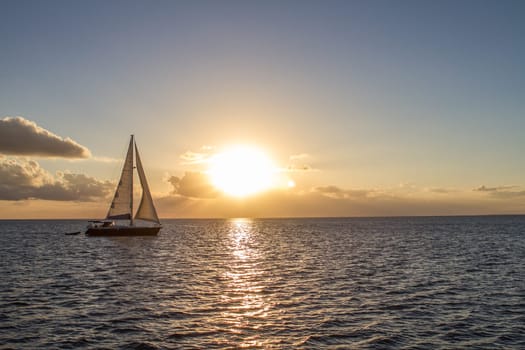 Yacht in the tropical sea at sunset sails