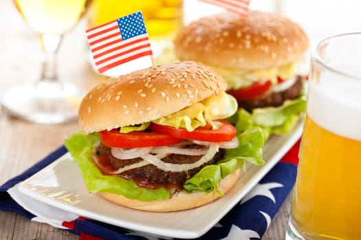 Beer and two tasty hamburgers with little American flags on top.