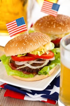 Beer and two tasty hamburgers with little American flags on top.