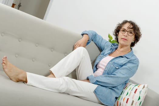 a beautiful mature woman lying on the couch