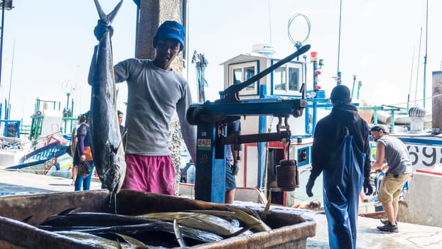 Taitung, Taiwan - May 28, 2016 : Fishing boats docked Chenggong Fishing Harbor remove fishing goods