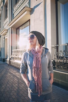 Stylish and fashionable girl on a walk around the city. Black and white knitted hat sneakers, pink socks. Outerwear, warm clothing. Fashionista. clothing items. Autumn clothes.