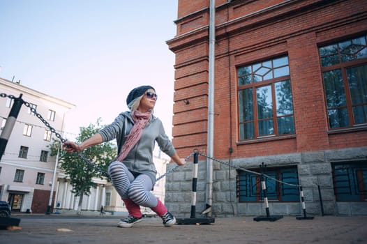 Stylish and fashionable girl on a walk around the city. Black and white knitted hat sneakers, pink socks. Outerwear, warm clothing. Fashionista. clothing items. Autumn clothes.
