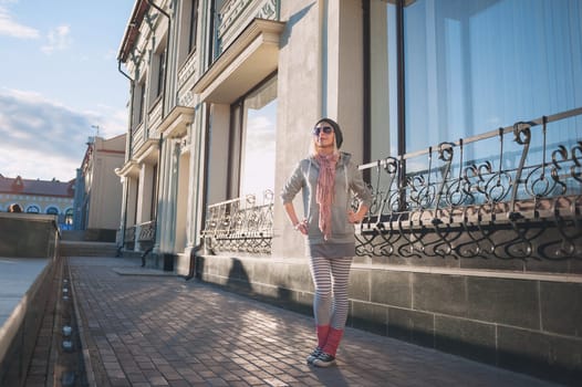 Stylish and fashionable girl on a walk around the city. Black and white knitted hat sneakers, pink socks. Outerwear, warm clothing. Fashionista. clothing items. Autumn clothes.