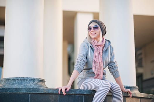 Stylish and fashionable girl on a walk around the city. Black and white knitted hat sneakers, pink socks. Outerwear, warm clothing. Fashionista. clothing items. Autumn clothes.