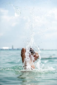 a boy plays in the ocean water splashes