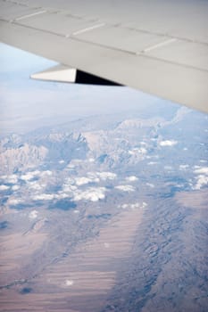 airplane wing above the clouds, blue sky