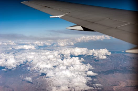 airplane wing above the clouds, blue sky