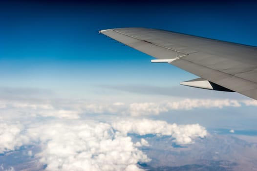 airplane wing above the clouds, blue sky