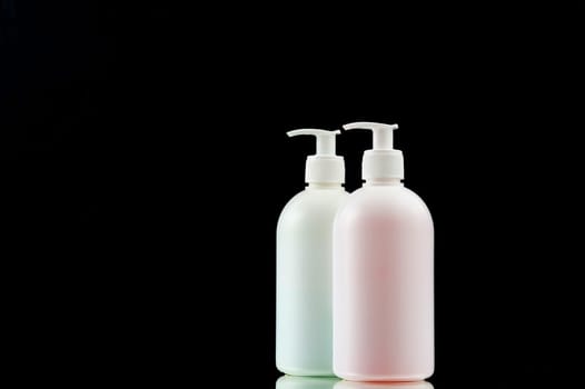 Plastic dispencer with liquid soap on a black background. Closeup