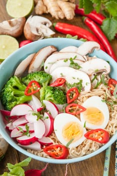 Asian noodle soup with fresh vegetables and boiled egg