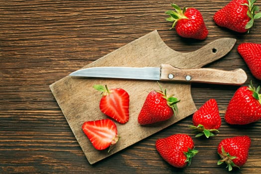 Fresh red strawberries on wooden background close up.