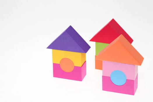 Toy house made of plastic bricks on white background