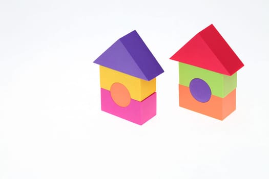 Toy house made of plastic bricks on white background