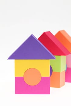 Toy house made of plastic bricks on white background