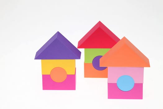 Toy house made of plastic bricks on white background