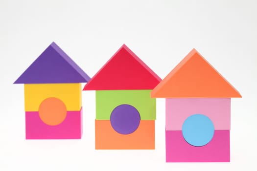 Toy house made of plastic bricks on white background