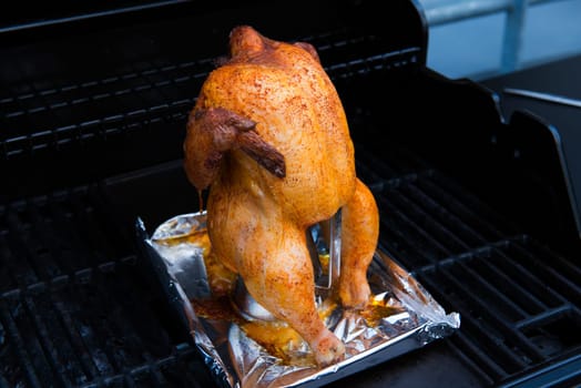 crunchy grilled completely chicken sitting on barbecue