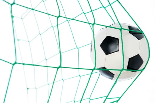 soccer ball in green goal in front of white background