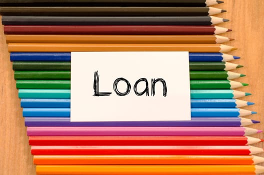 Loan text concept and colored pencil on wooden background