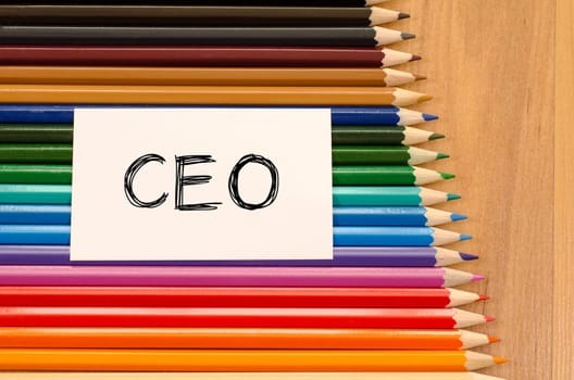 Ceo text concept and colored pencil on wooden background
