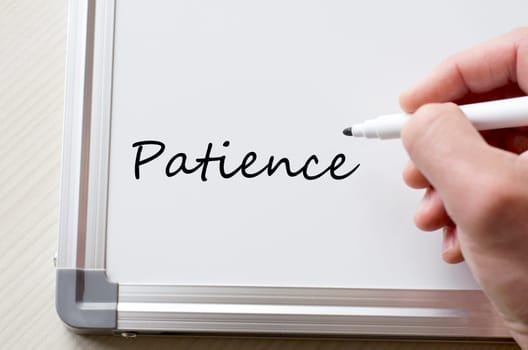 Human hand writing patience on whiteboard