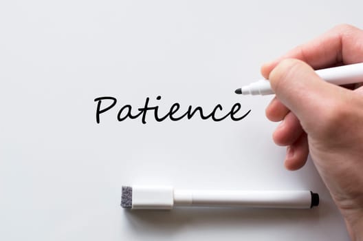 Human hand writing patience on whiteboard