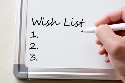 Human hand writing wish list on whiteboard