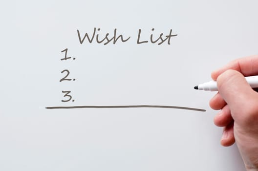 Human hand writing wish list on whiteboard